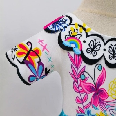 Vestido infantil branco com padrões coloridos e bordado em arco-íris