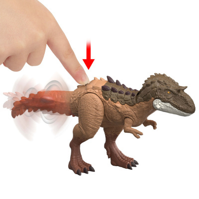 Brinquedo de dinossauro castanho com cauda móvel e dedo humano a pressionar