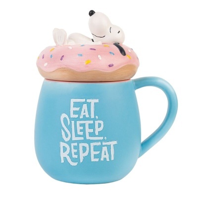 Caneca azul com texto branco e tampa de donut rosa com figura de Snoopy