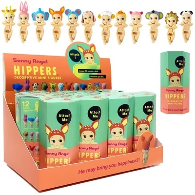 Expositor com figuras decorativas mini Sonny Angel HIPPERS e embalagens verdes com texto 'Attach Me'.