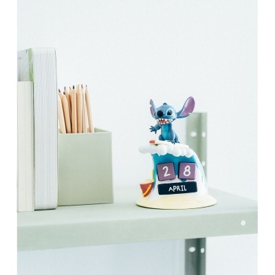 Relógio de madeira decorativo com figura do Stitch a surfar e blocos com data na prateleira cinza