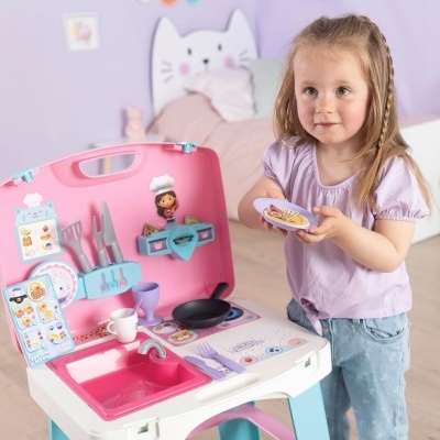 Cozinha de brinquedo cor de rosa com acessórios em quarto infantil