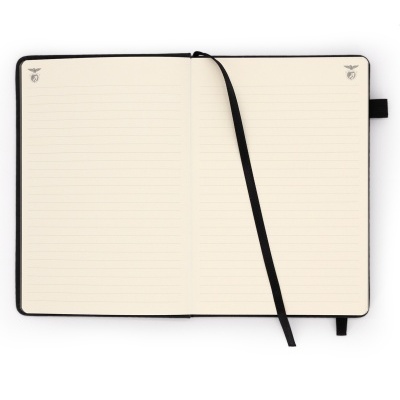 Caderno aberto com páginas pautadas e fita preta