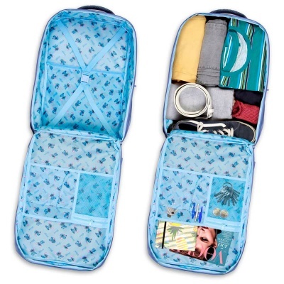 Mala de viagem azul claro aberta com roupas, acessórios e objetos organizados