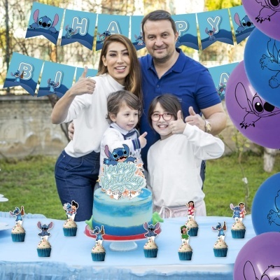 Festa de aniversário com tema Stitch, bolo azul, cupcakes, bandeirolas azuis e balões em ambiente exterior