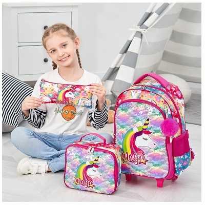 Mochila infantil colorida com unicórnio e estojo combinando ao lado de menina sorridente.