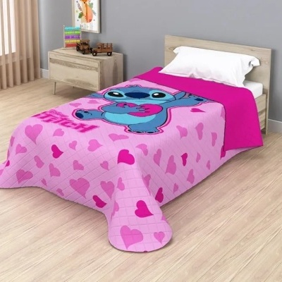 Cama individual com cobertor rosa com corações e personagem azul em quarto com chão de madeira