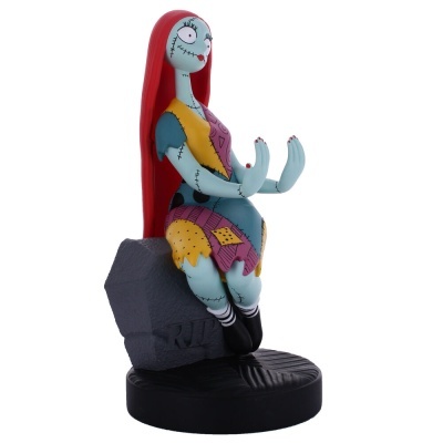 Estatueta da personagem Sally com cabelo vermelho e vestido colorido sentada numa lápide cinza