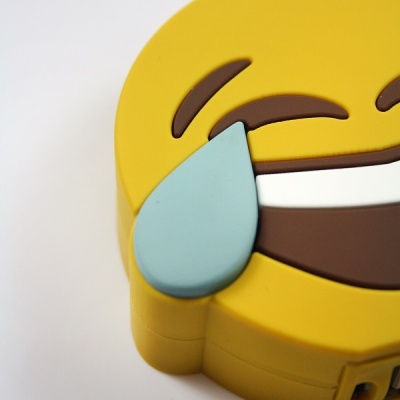 Emoji amarelo sorridente com lágrima azul de plástico