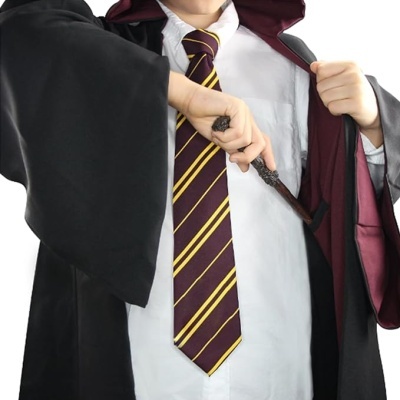 Criança com roupa estilo mago segurando uma varinha mágica.