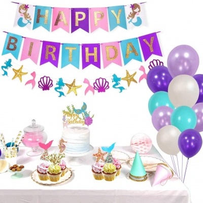 Decoração de festa de aniversário com tema de sereias, balões coloridos e bolo com cupcakes
