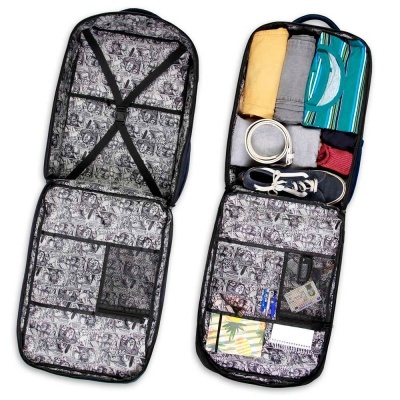 Malas de viagem abertas com interior estampado a preto e branco, uma com roupas e acessórios e outra vazia.