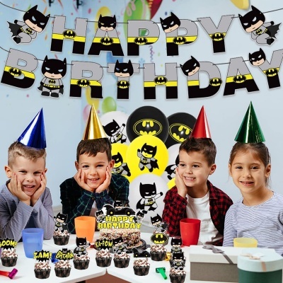 Festa de aniversário com decoração e cupcakes temáticos do Batman e crianças felizes com chapéus de festa