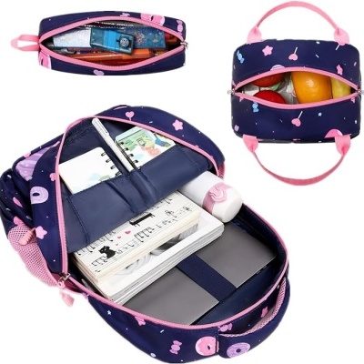 Mochila escolar azul escura com padrão rosa e vários compartimentos abertos contendo material escolar e frutas