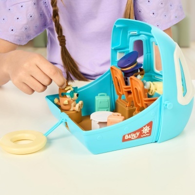 Barco de brinquedo azul com figuras e cadeiras laranja