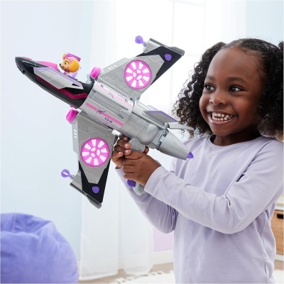 Menina segurando brinquedo de avião espacial cinza e rosa com luzes cor-de-rosa