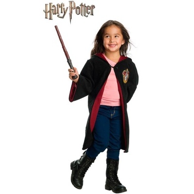 Criança com capa Harry Potter e varinha mágica