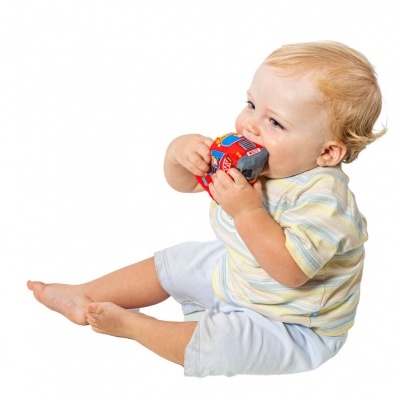 Bebé a morder brinquedo de carro vermelho sentado sobre fundo branco