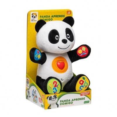 Ursinho de peluche preto e branco com figuras coloridas e botão vermelho na embalagem amarela