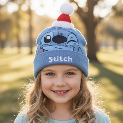 Gorro azul de malha com personagem Stitch e pompom vermelho e branco usado por criança sorridente