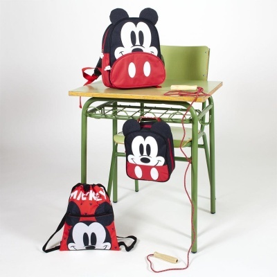 Mochilas com design do Mickey Mouse numa secretária escolar verde com tampo de madeira