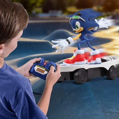 Brinquedo do Sonic azul em base com rodas controlado remotamente por menino.