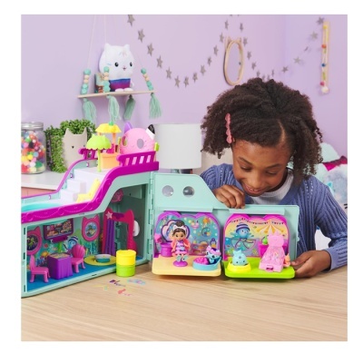 Menina a brincar com brinquedo de casa de bonecas colorida em ambiente infantil