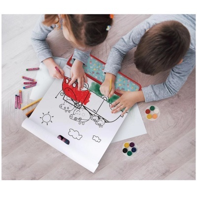 Crianças a pintar desenho de comboio com lápis de cor e tintas no chão claro