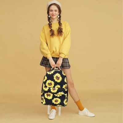 Mochila com padrão de girassóis nas mãos de mulher com roupa casual em fundo bege.