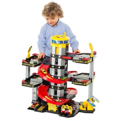 Parque de estacionamento de brinquedo com rampa espiral e carrinhos coloridos, criança a brincar