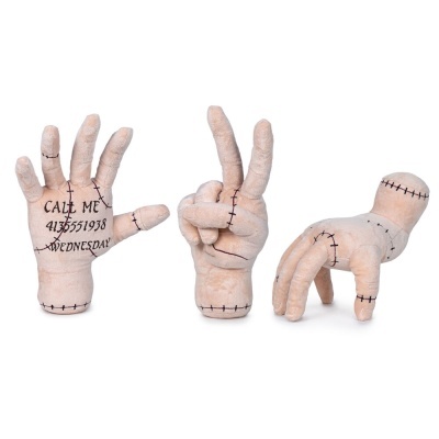 Três almofadas em forma de mãos de tecido cor pele com costuras a preto e texto na palma de uma delas