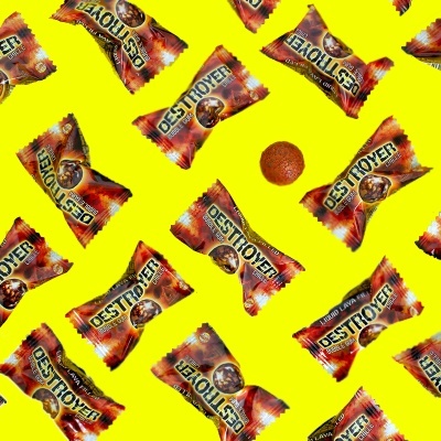 Pacotes de snacks DESTROYER com bolinha alaranjada sobre fundo amarelo