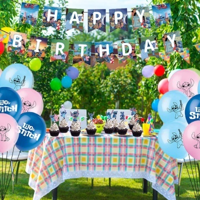 Decoração de festa infantil com tema Stitch, balões e bandeirolas em ambiente ao ar livre