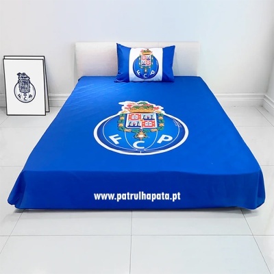 Cama com lençol e almofada azuis com símbolo do F.C. Porto