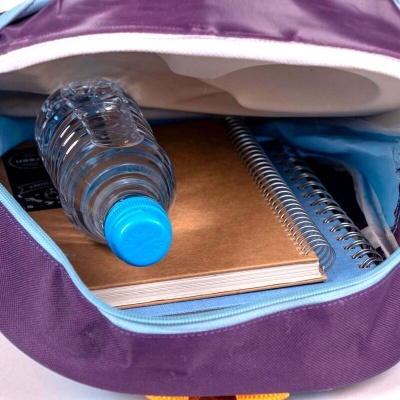 Mochila roxa aberta com garrafa de água, dois cadernos e fone de ouvido