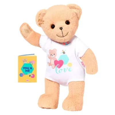 Ursinho de peluche com camisa branca e livro amarelo com texto