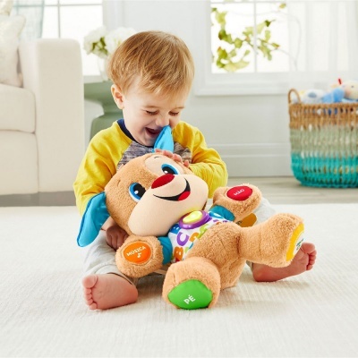 Menino brincando com cão de peluche com botões coloridos