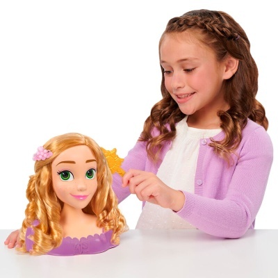Boneca manequim com cabelo loiro encaracolado e menina a pentear o cabelo da boneca