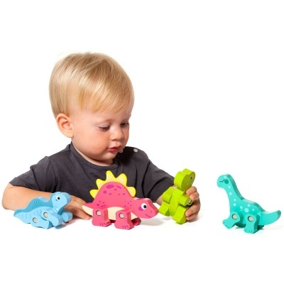 Criança a brincar com dinossauros de madeira coloridos