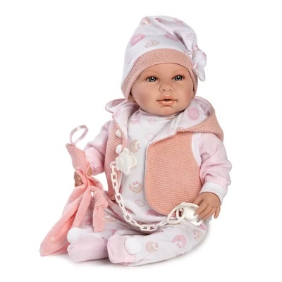Boneca bebé vestida com pijama e colete cor-de-rosa segurando pano e chupeta.