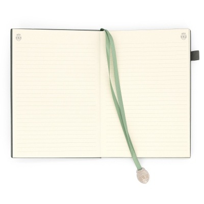 Caderno aberto com páginas forradas por linhas e marcador verde com pendente SCP