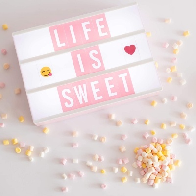 Caixa de luz com a frase LIFE IS SWEET e pequenas pastilhas coloridas