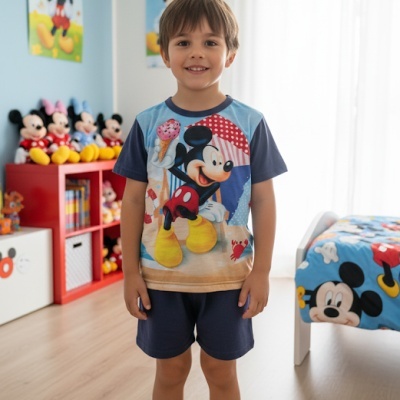 Criança com pijama do Mickey numa divisão com decoração temática do Mickey