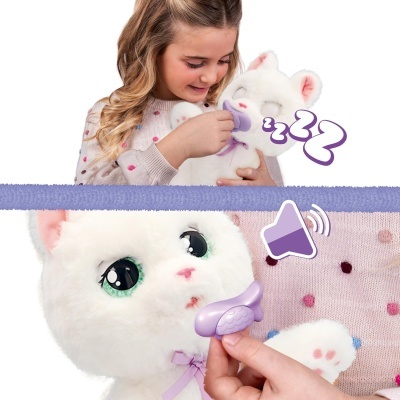 Criança segurando brinquedo de gato de pelúcia branco com olhos verdes e laço lilás.