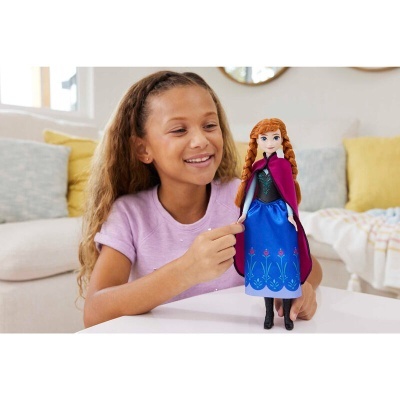 Boneca Anna da Disney com vestido azul e casaco vermelho nas mãos de menina