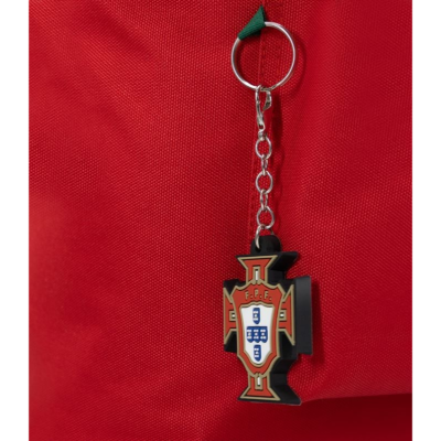 Chaveiro metálico com emblema do SC Farense pendurado em tecido vermelho