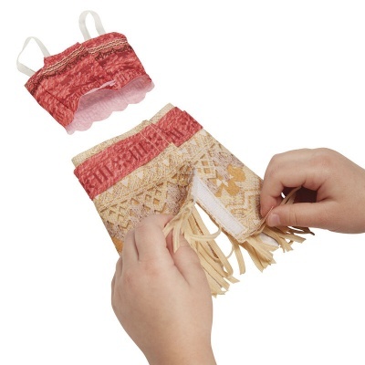 Conjunto de roupa para boneca com top vermelho e saia com padrão e franjas.