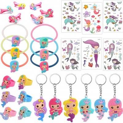 Conjunto colorido de acessórios infantis de sereia, incluindo anéis, presilhas, argolas de cabelo, porta-chaves e autocolantes.