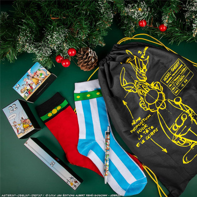 Conjunto de meias coloridas, caneta, caixas numeradas e saco preto com desenho amarelo em fundo verde e decoração de Natal.