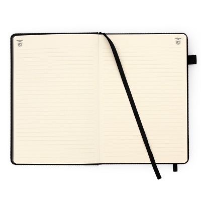 Caderno aberto com páginas pautadas e fita marcadora preta